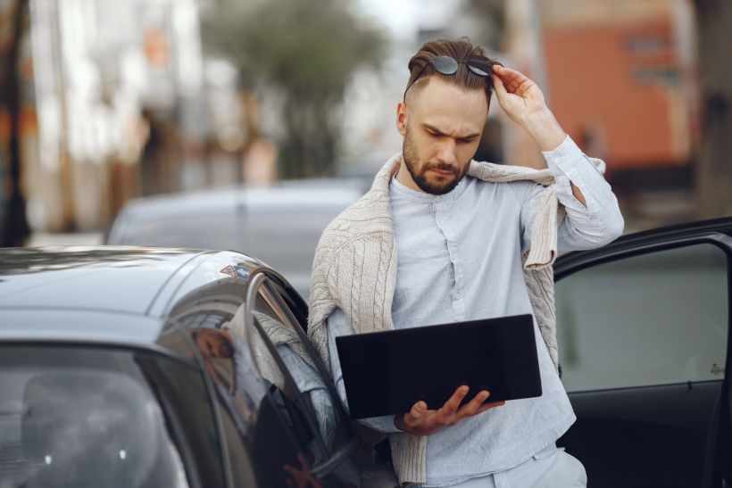 Young businessman walking on the street seems troubled with documents.