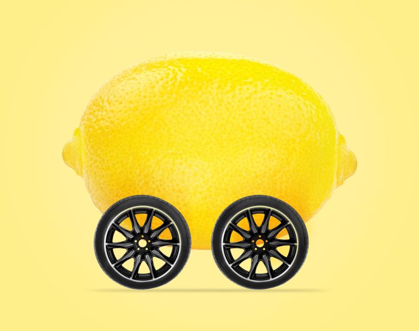 Lemon car concept lemon with wheels isolated on light yellow background.