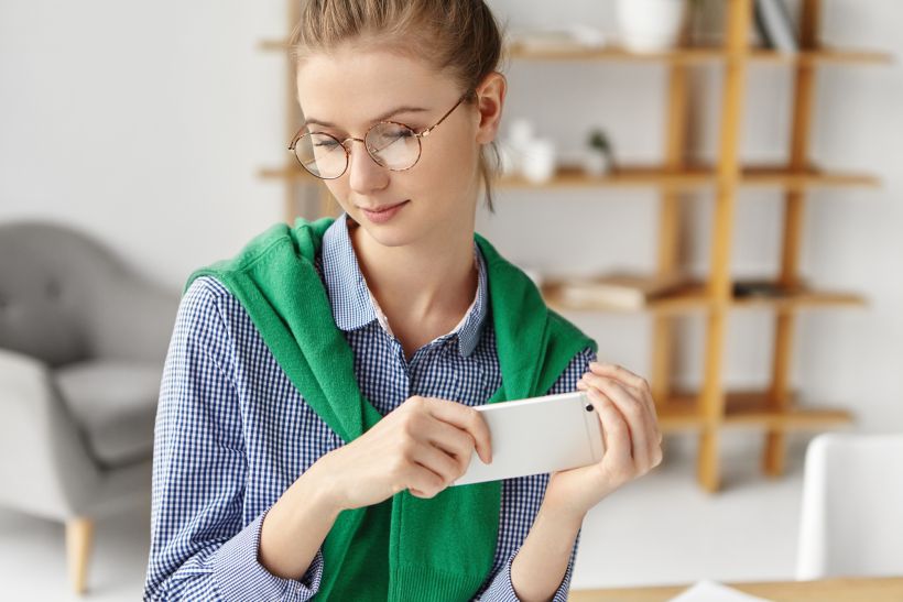 Beautiful woman dressed formally in office with phone.