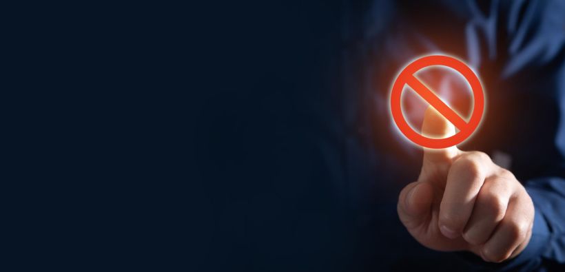 Male hand touching in a stop sign.