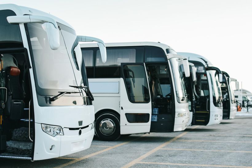 Row of tourist buses at parking lot.
