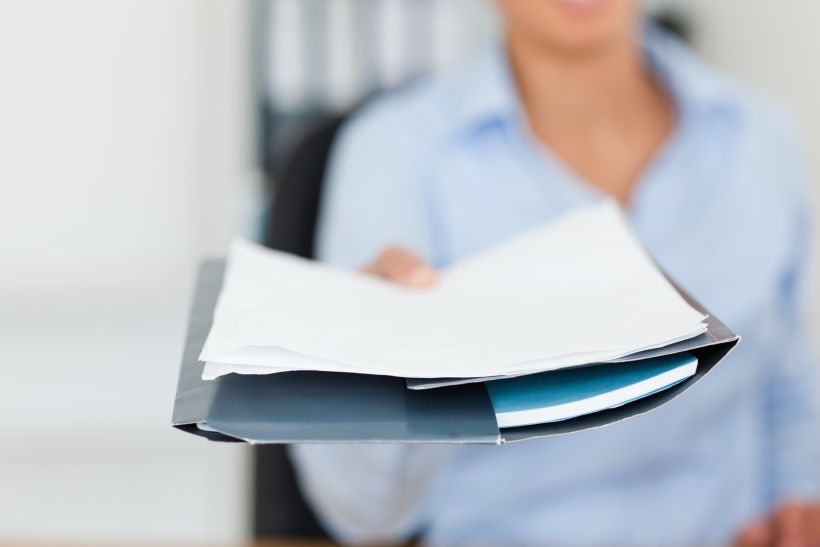 Beautiful woman showing a sheet of paper to the camera.