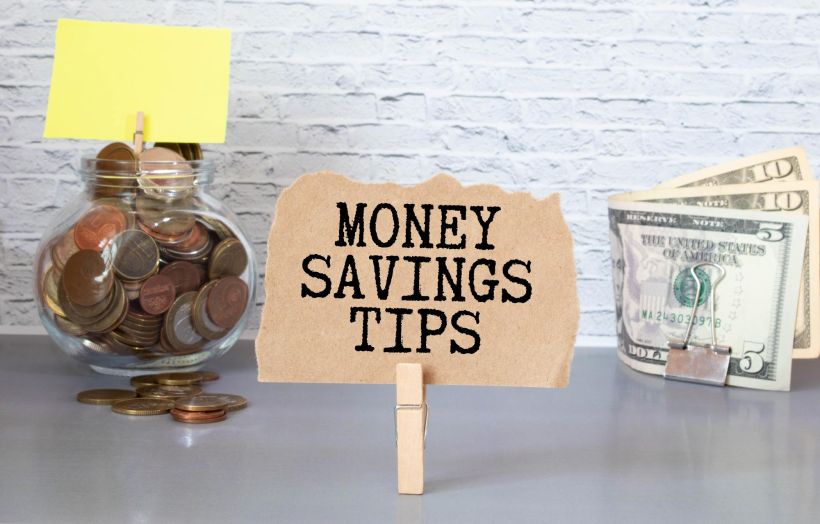 Money savings tips text on small notepad with pen and calculator.