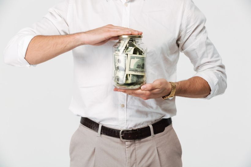 Close up portrait of a man in shirt holding jar with money.