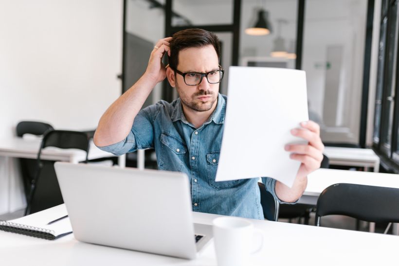 A surprised young man looks at the document.