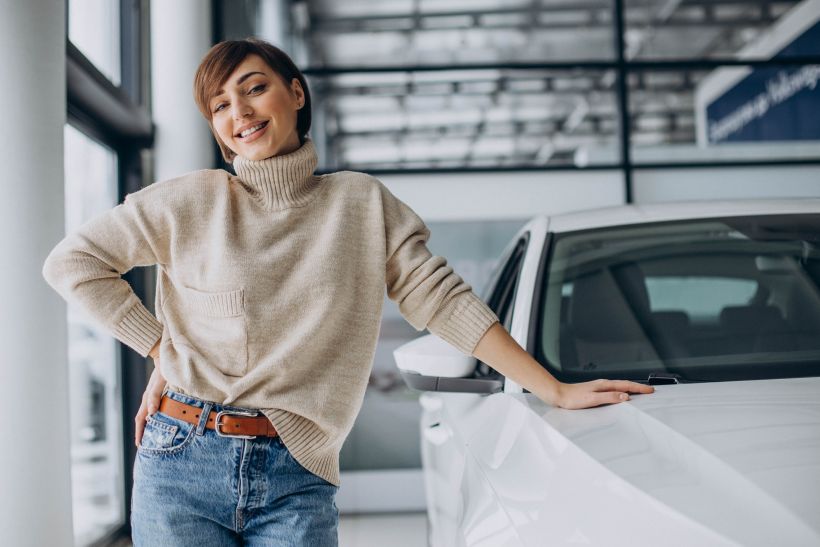 Woman in a car showroom choosing a new car.