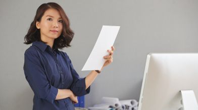 A confident woman reviews the required paperwork for a lien release on car title