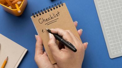 A person writing a checklist on how to transfer a car title in california